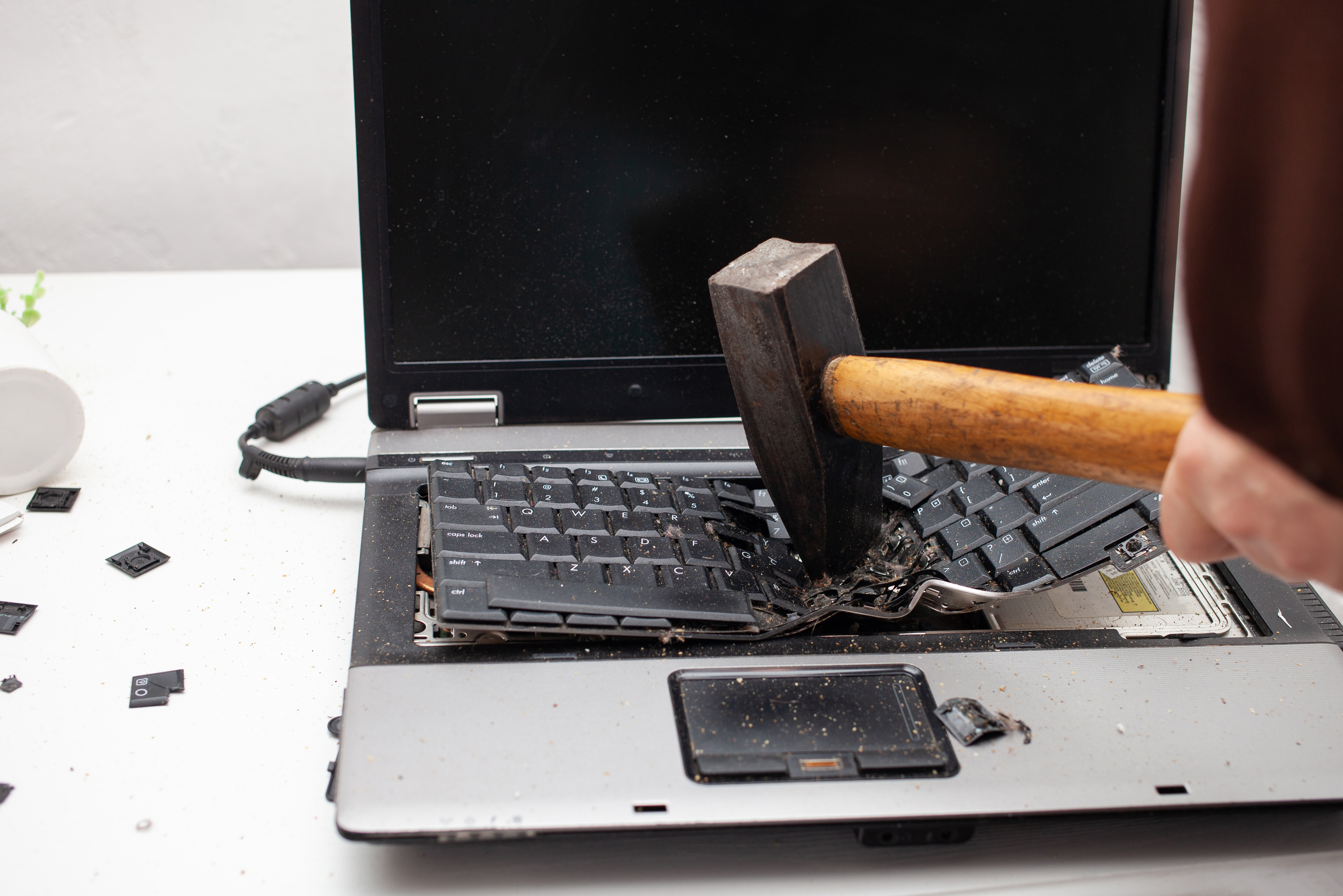 Man smashing laptop with hammer
