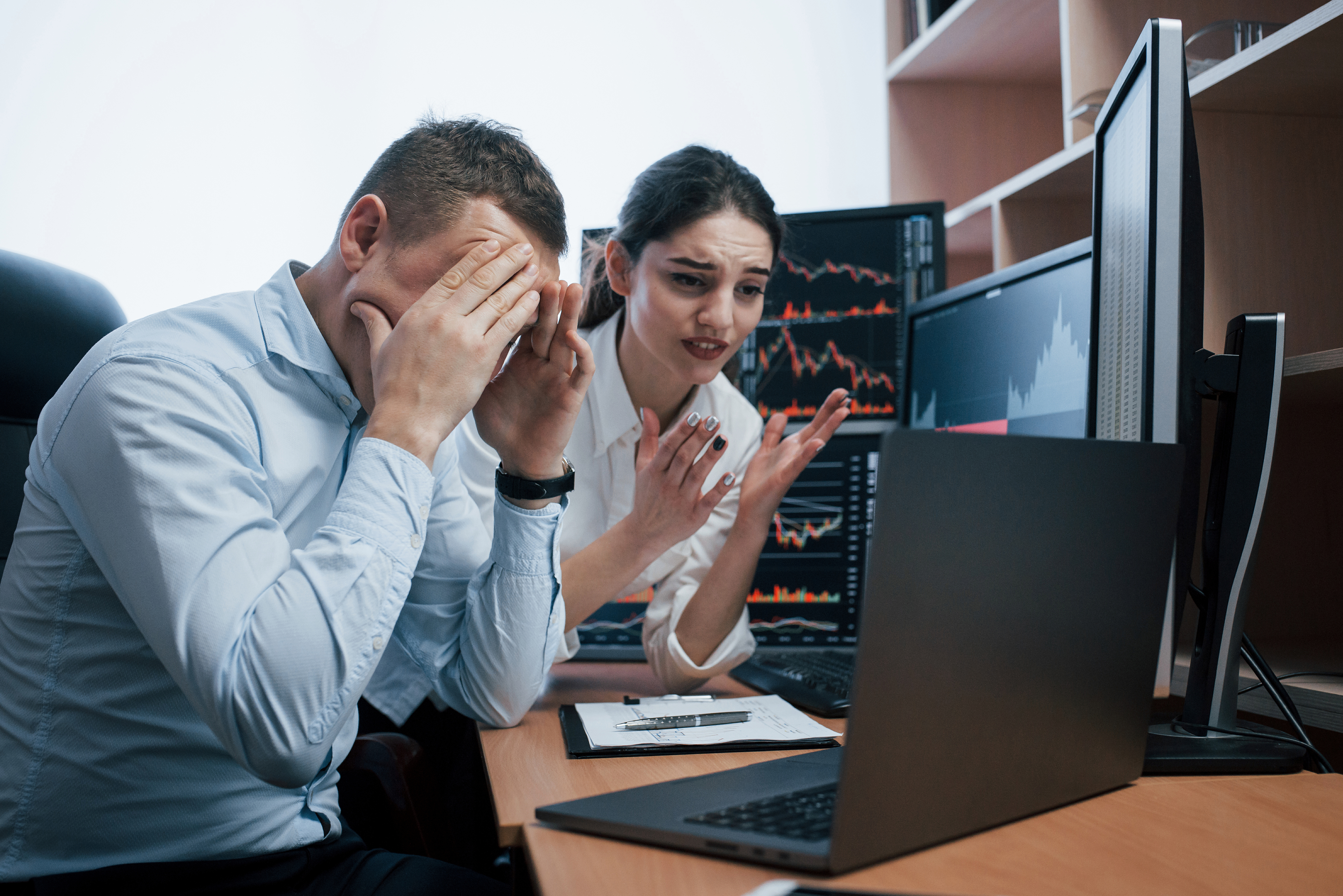 Stressed office workers looking at laptop